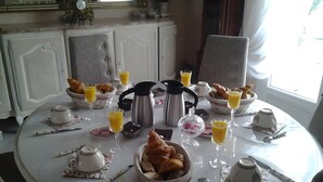 Ein Frühstückstisch mit Croissants, Kaffee und Orangensaft.