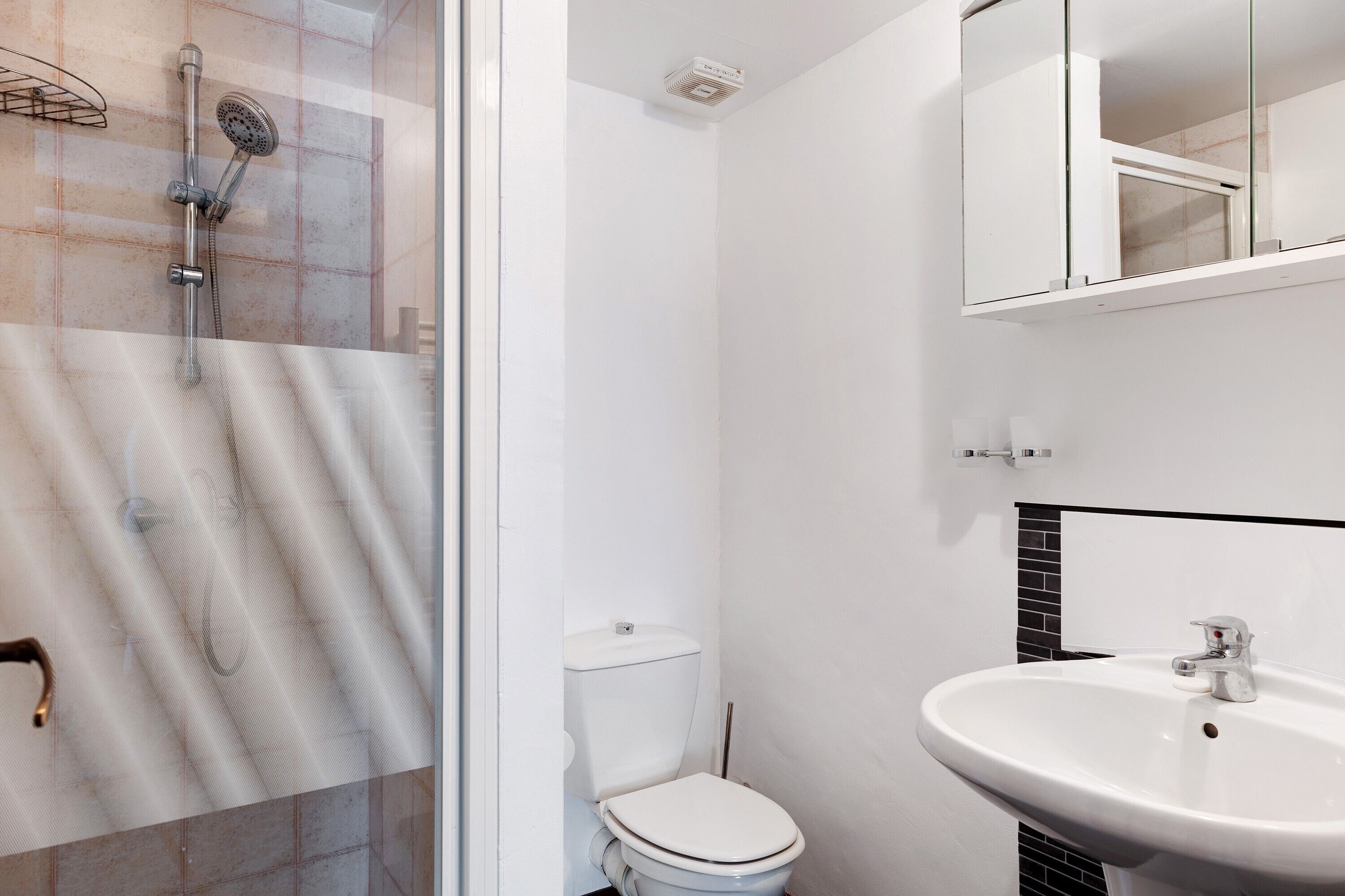 A bathroom with a shower, toilet, and sink.