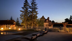 A pool area with lounge chairs, a wooden pergola, and a large tree. - Quercy Room – Romantic & Authentic Retreat (Gramat)