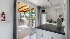 A kitchen with a microwave, refrigerator, and a gas stove. - Bungalow "Les Lodges Des Pins" with Shared Pool (Lège-Cap-Ferret)
