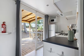 Una cocina equipada con microondas, refrigerador y estufa a gas.
