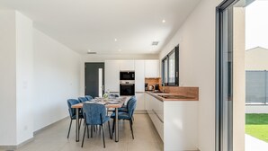A modern kitchen with white cabinets, a wooden countertop, and a built-in oven. - Modern Villa with Pool, Wi-Fi, and Air Conditioning (Beaucaire)