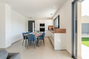 A modern kitchen with white cabinets, a wooden countertop, and a built-in oven. - Holiday Home 'Villa Moderne Avec Piscine' with Private Pool, Wi-Fi and Air Conditioning (Beaucaire)