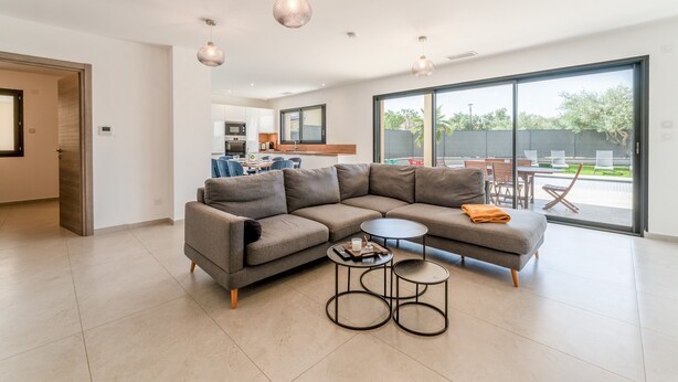 A modern living room with a sectional sofa, two round coffee tables, and pendant lighting. - Modern Villa with Pool, Wi-Fi, and Air Conditioning (Beaucaire)