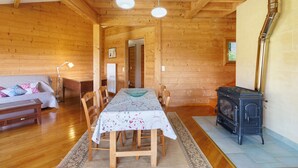 Un intérieur en bois comprenant une table à manger, des chaises, un canapé, une cheminée et une lampe.