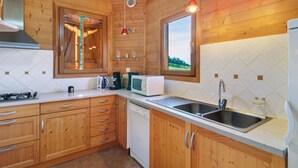 Une cuisine en bois équipée d’une cuisinière, d’un four à micro-ondes, d’un évier et de placards.