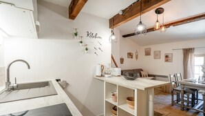 Eine moderne Küche mit Einbauherd, Spüle und Essbereich mit Tisch und Stühlen.