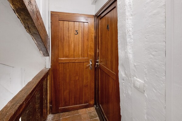 A wooden door with a number '3' on it, a metal handle, and a keyhole.