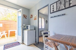 Une cuisine compacte équipée d’un réfrigérateur, d’un four à micro-ondes et d’un coin repas avec une table et des chaises.