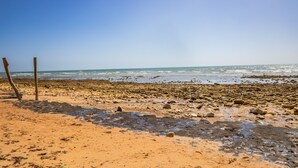 Een kiezelstrand met een heldere lucht.