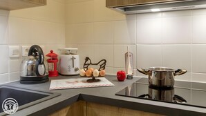 Eine Küche mit Wasserkocher, Toaster, Eiern, einem roten Apfel und einem Topf auf dem Herd.
