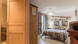 Ein Schlafzimmer mit Bett, Holzschrank und einem Vorhangfenster.