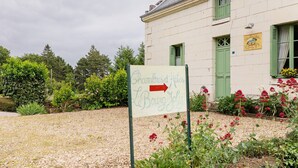 Señal de Chambres d'Hotes L'Erve, con un camino de grava y jardín delantero.