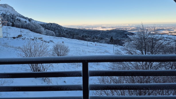 Un paisaje nevado con una vista despejada de una cadena montañosa y un valle.