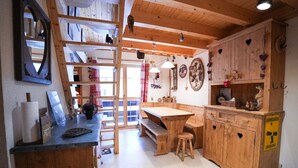 A wooden interior with a wooden table, bench, and ladder.