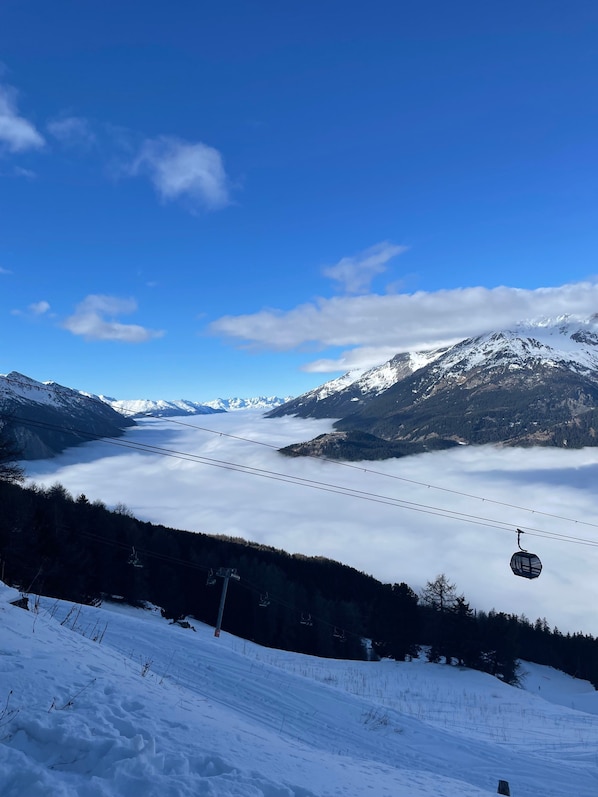 A snow-covered mountain landscape with a ski lift and a clear blue sky.