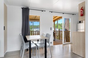 Una cocina moderna con microondas, un mueble de madera y un ventanal corredero a un balcón.