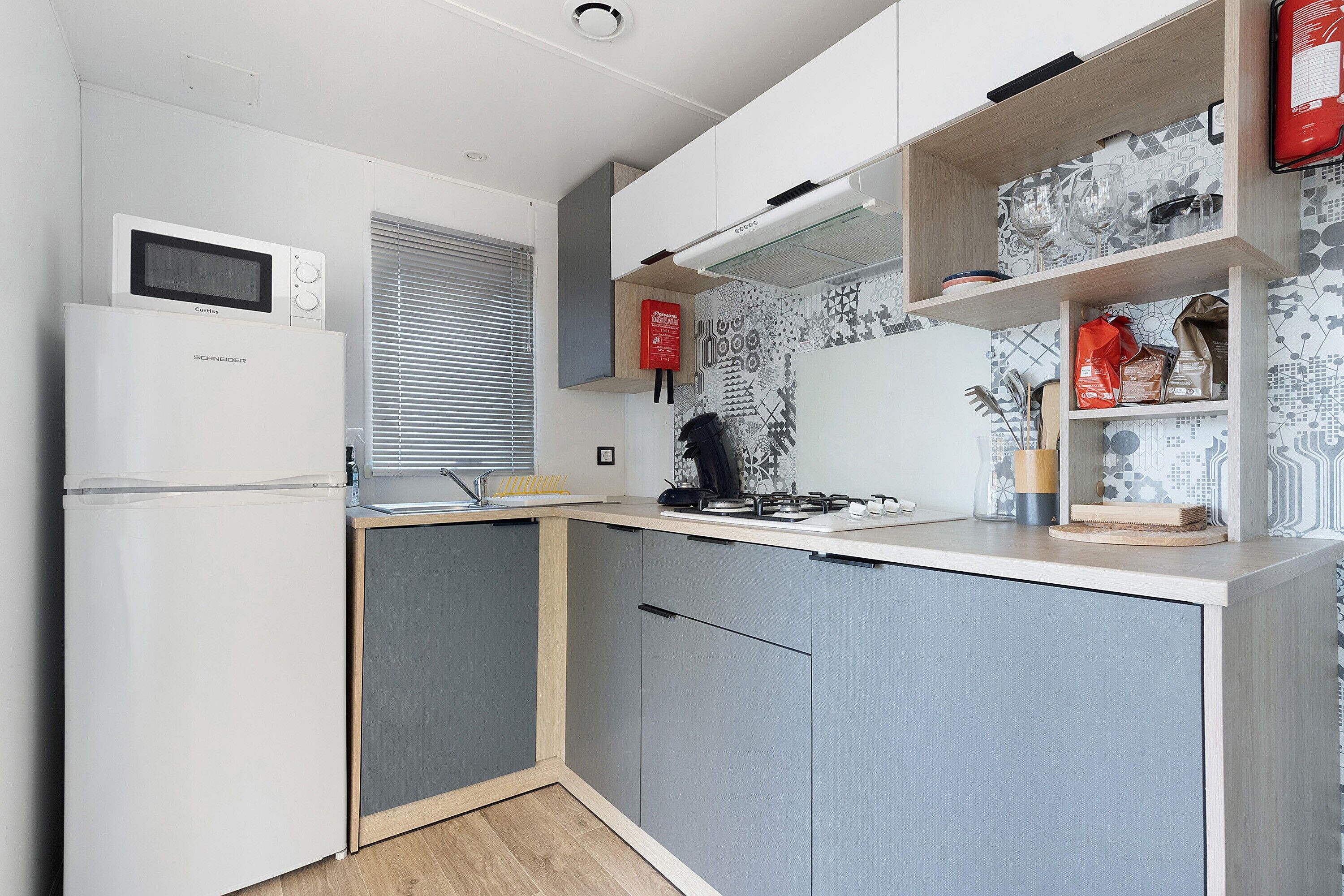 A compact kitchen with a microwave, stove, and built-in oven.