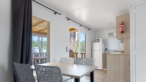 Une cuisine moderne équipée d’un four à micro-ondes, d’un évier et d’un meuble en bois. On y trouve également un coin repas avec une table et des chaises.