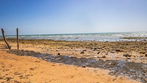 Une plage de galets sous un ciel dégagé.