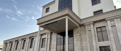 A large, multi-story building with a classical architectural style, featuring columns and decorative moldings.