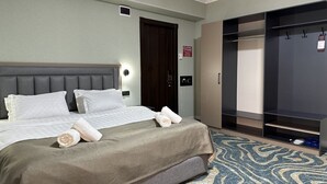 A hotel room with a bed, a wardrobe, and a bathroom. - Reikartz Grand Kokand (Kokand)