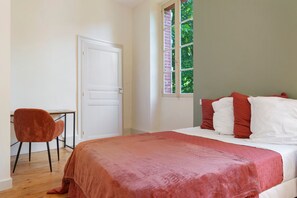 Une chambre Ă coucher avec un lit, une fenĂȘtre, une porte et une chaise.