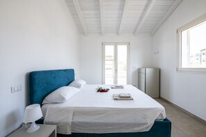 A bedroom with a bed, a nightstand, a lamp, a window, and a door. - The apartment is modern, well-organized, and designed to offer comfort and functionality throughout your stay. The spaces are bright and airy, with a layout that allows for easy movement even with multiple guests.It features two bedrooms: one with a doub (Lido di Camaiore)