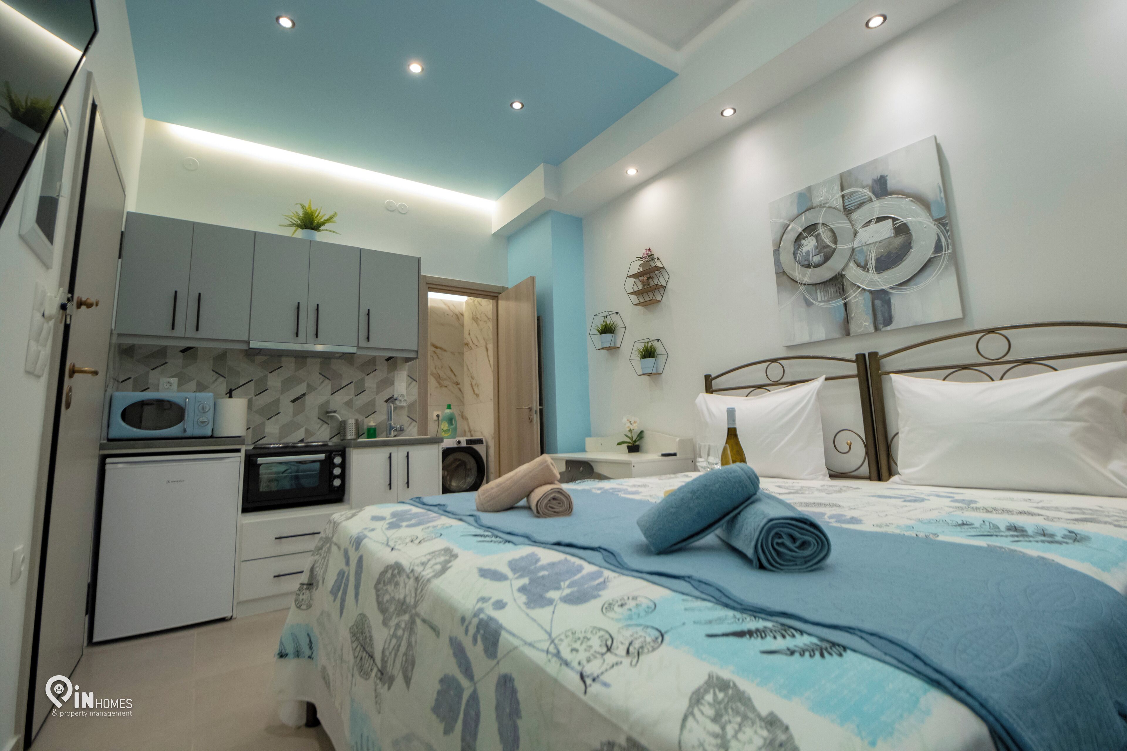 A modern bedroom with a bed, a nightstand, and a bathroom visible in the background.