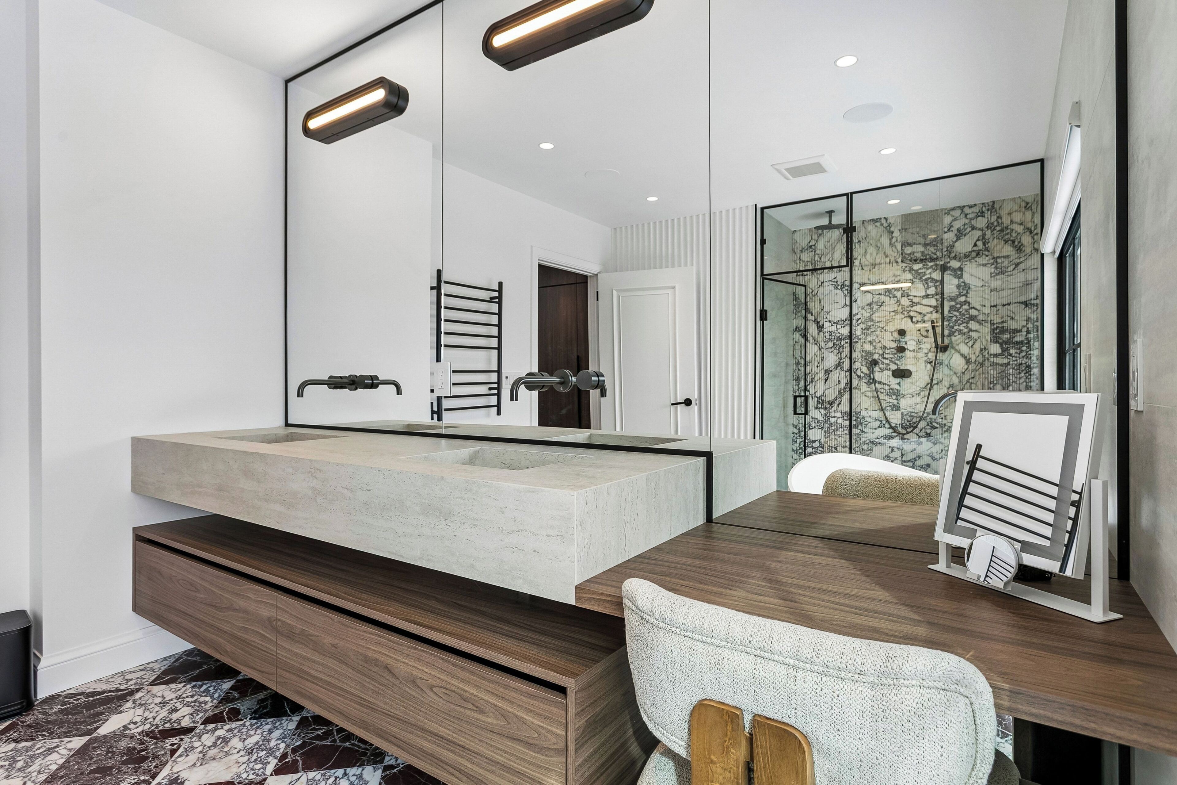 Une salle de bain moderne avec un grand miroir, un lavabo intégré et un espace douche.