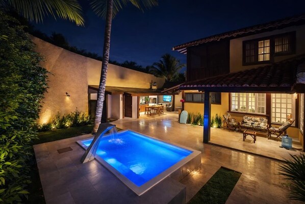 A modern house with a swimming pool, outdoor seating, and a well-lit patio area. - Complete house in Búzios with pool and gourmet area for up to 10 people. (Armação dos Búzios)