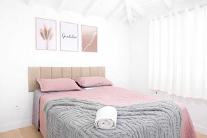 A bedroom with a bed, pillows, a blanket, and three framed pictures on the wall. - Complete house in Búzios with pool and gourmet area for up to 10 people. (Armação dos Búzios)