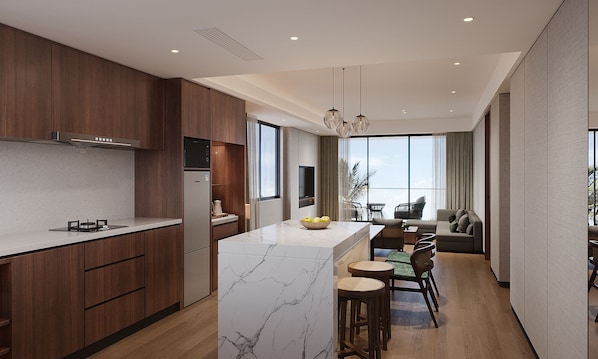 A modern kitchen with a marble island, wooden cabinets, and a dining area with a sofa and chairs. - The Sebel Nuku Loaloa (Nadi)