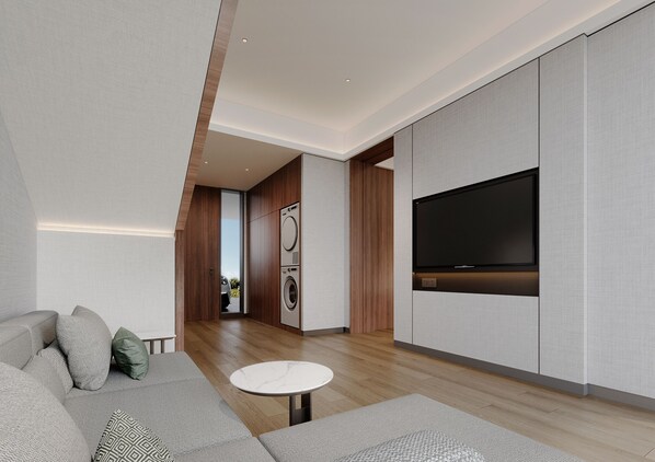 A modern living room with a sofa, a small round table, and a flat-screen TV mounted on a wall. - The Sebel Nuku Loaloa (Nadi)