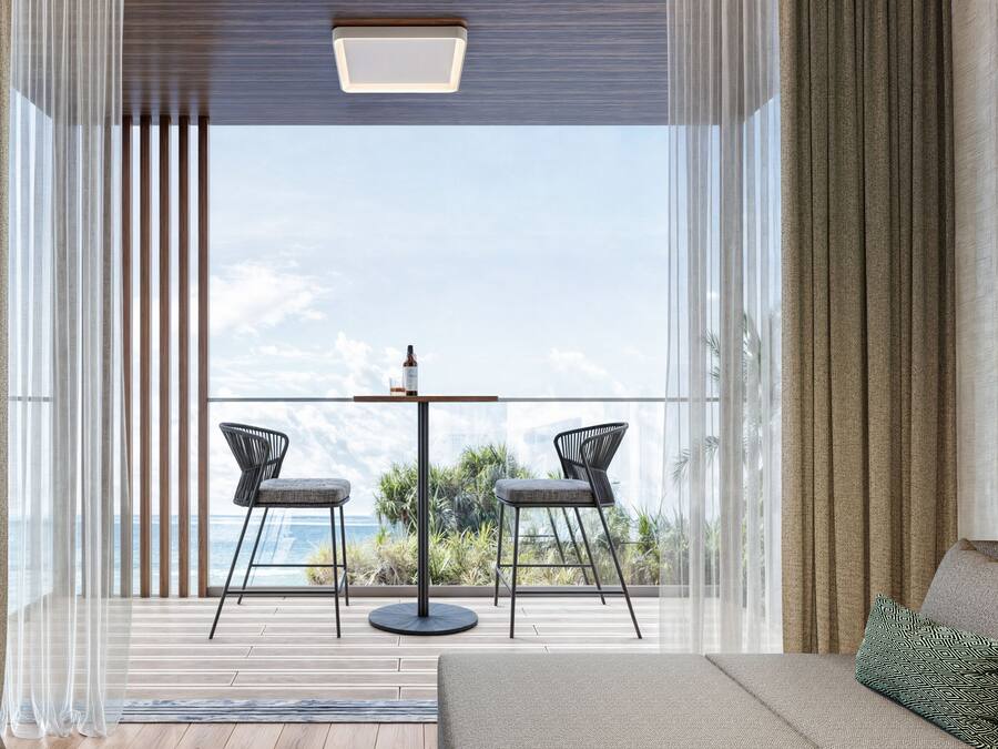 A modern living room with a large window, two chairs, a small table, and a sofa.