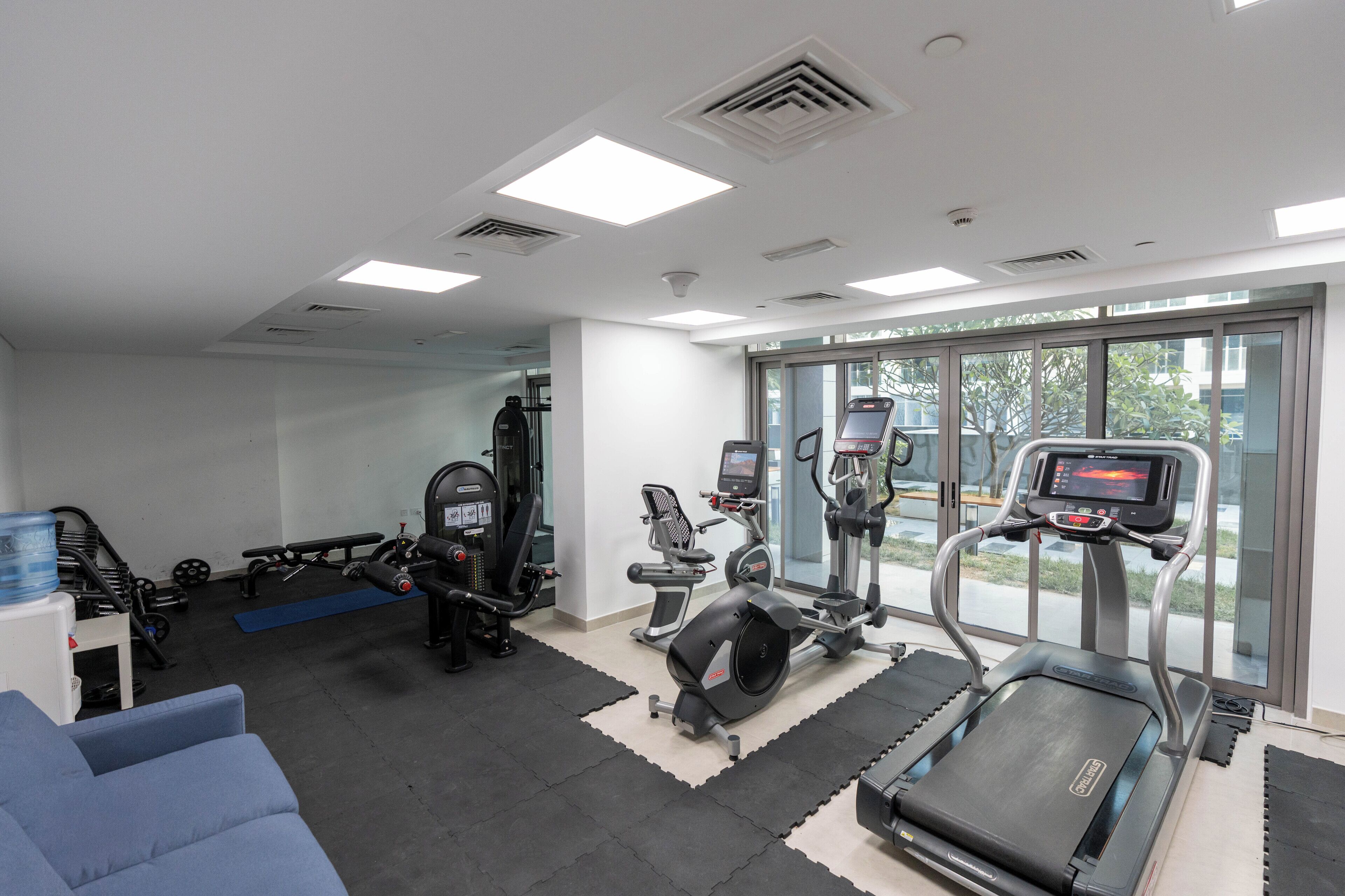 Ett modernt gym med löpband, crosstrainers och styrketräningsutrustning.