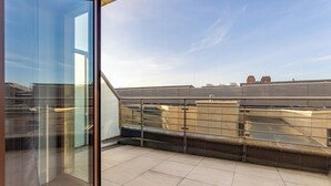 Un edificio alto con un balcón de vidrio y vistas a la ciudad.