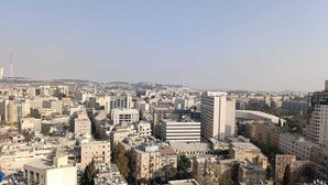 A cityscape with various buildings, including a prominent curved structure and several high-rise buildings. - King George palace (Jerusalem)