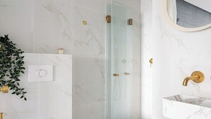 A modern bathroom with a glass-enclosed shower, a white toilet, and a marble-tiled floor. - King George palace (Jerusalem)