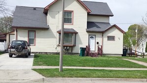 A two-story house with a garage, a front porch, and a driveway.