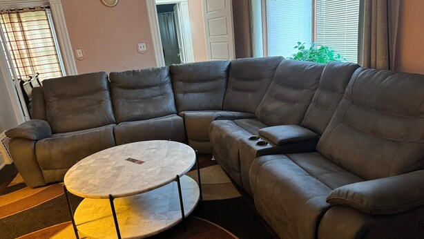 A sectional sofa with a round coffee table in a living room.