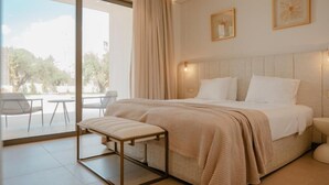 A modern hotel room with a large bed, a bench, and a view of the outdoors. - Soleil Villas (Zakynthos)