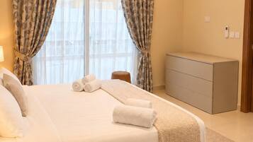 A modern bedroom with a bed, curtains, a bedside table, a dresser, and an air conditioning unit.