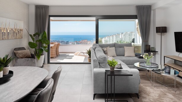 A modern living room with a sofa, a dining table, and a TV.
