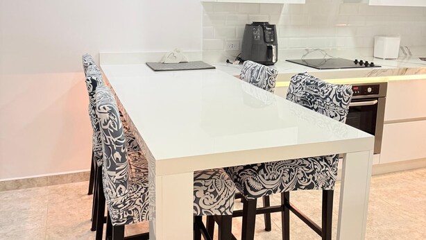 A modern kitchen with white cabinets, a built-in oven, and a coffee machine. - Beautiful apartment (Porlamar)