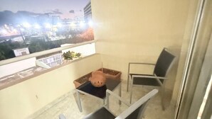 A balcony with two chairs, a small table, and a potted plant. - Beautiful apartment (Porlamar)