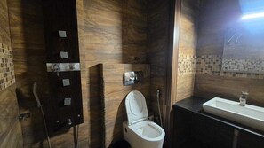 Une salle de bain moderne équipée de toilettes, d’un lavabo et d’un espace douche.