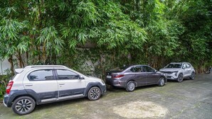 Three cars parked in a covered area with dense bamboo foliage in the background. - Alaya Stays Impreza Luxury stays (Dehradun)