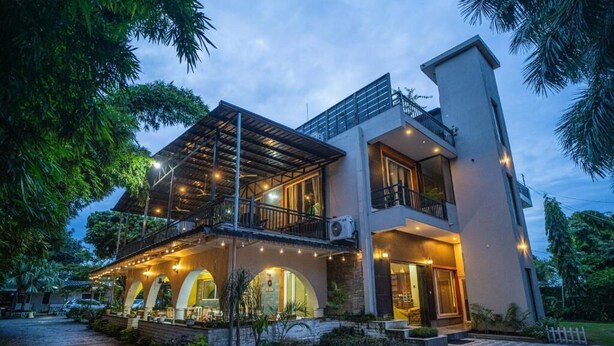 A modern two-story house with a balcony, a covered porch, and a stone pathway leading to the entrance. - Alaya Stays Impreza Luxury stays (Dehradun)