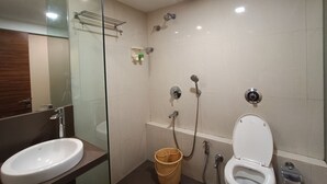 A modern bathroom with a glass shower enclosure, a white sink, and a toilet. - Rajhans Hotel (Mumbai)